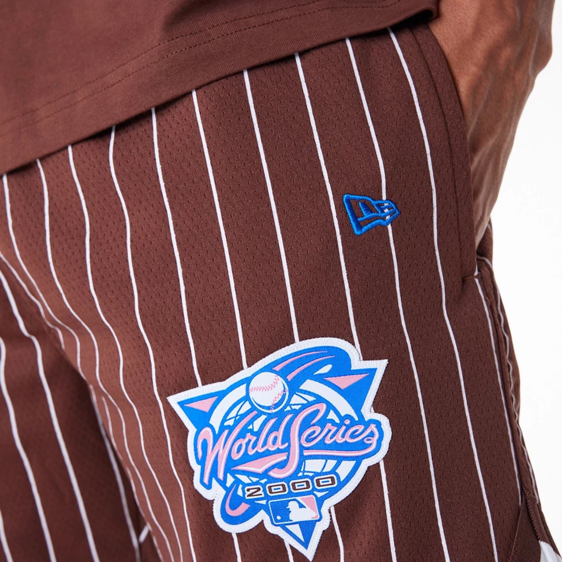 The Male model is wearing New York Yankees Pinstripe New Era Australia Brown Shorts 5