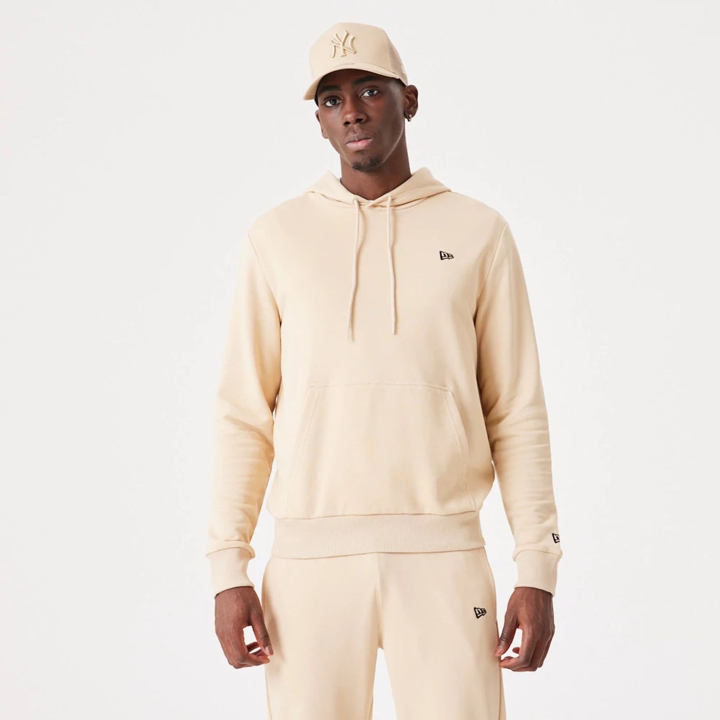 The Male model is wearing New Era Essential Light Beige Pullover Hoodie 2