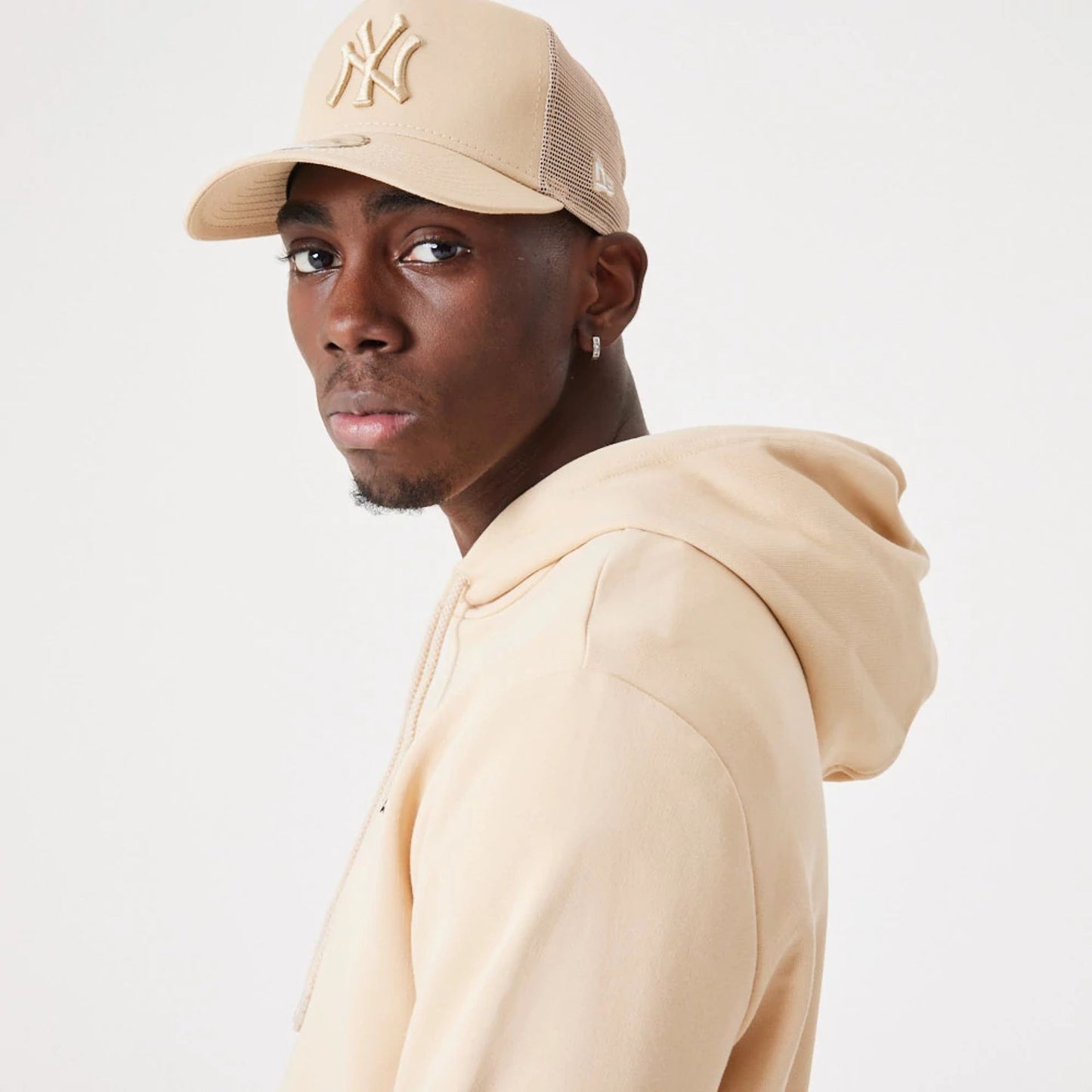 The Male model is wearing New Era Essential Light Beige Pullover Hoodie 7