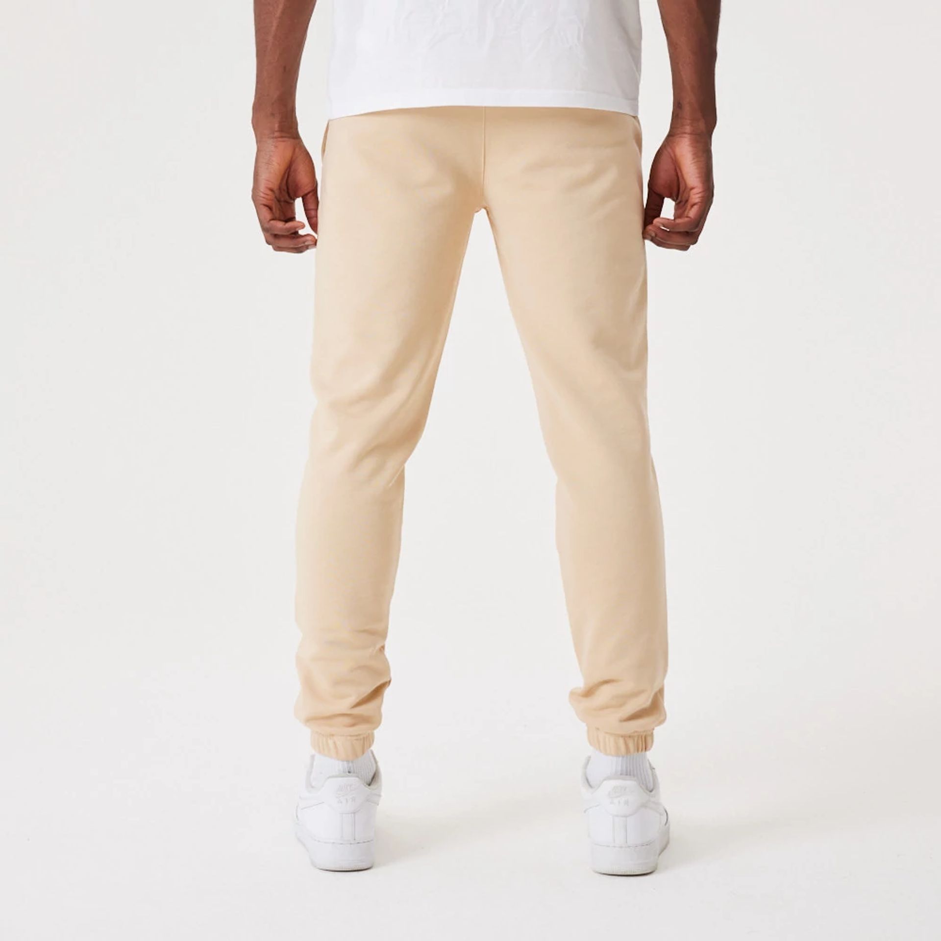 The Male model is wearing New Era Essential Light Beige Joggers 2