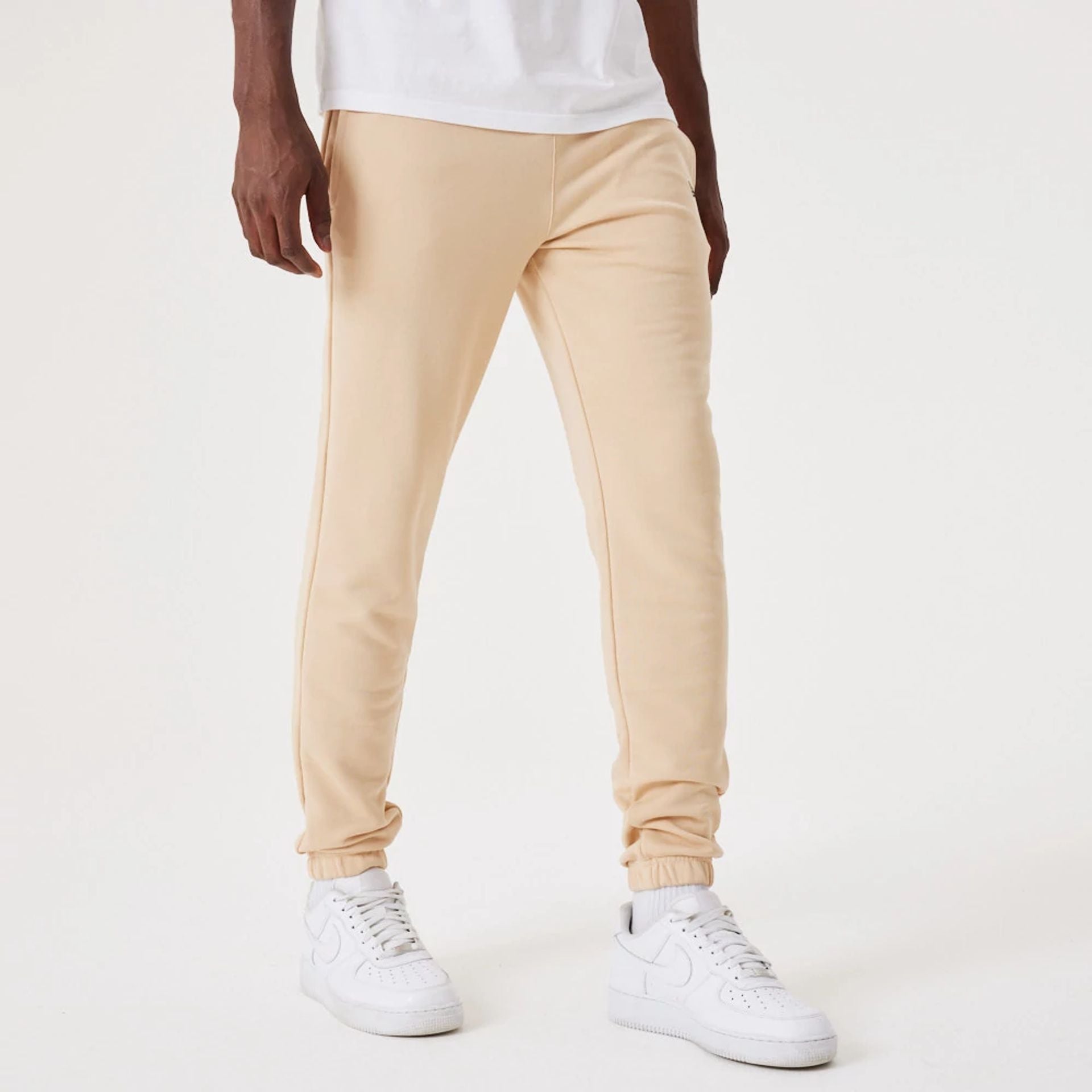 The Male model is wearing New Era Essential Light Beige Joggers 3