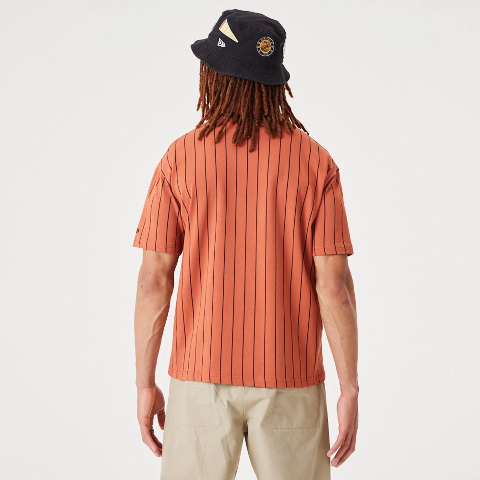 The Male model is wearing New Era Pinstripe Medium Brown Oversized T-Shirt 2