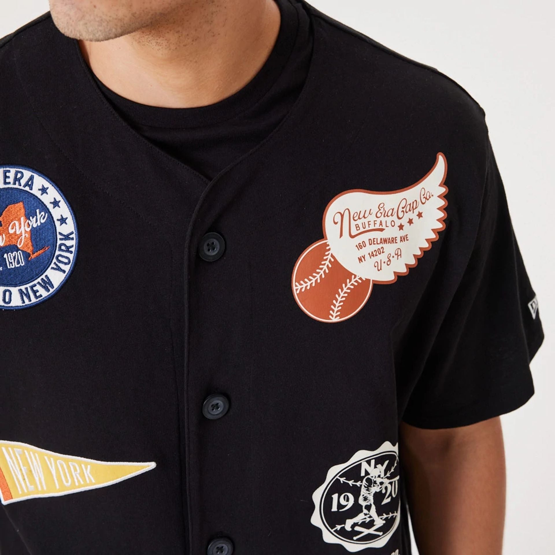 The Male model is wearing New Era Heritage Badge Black Jersey 5