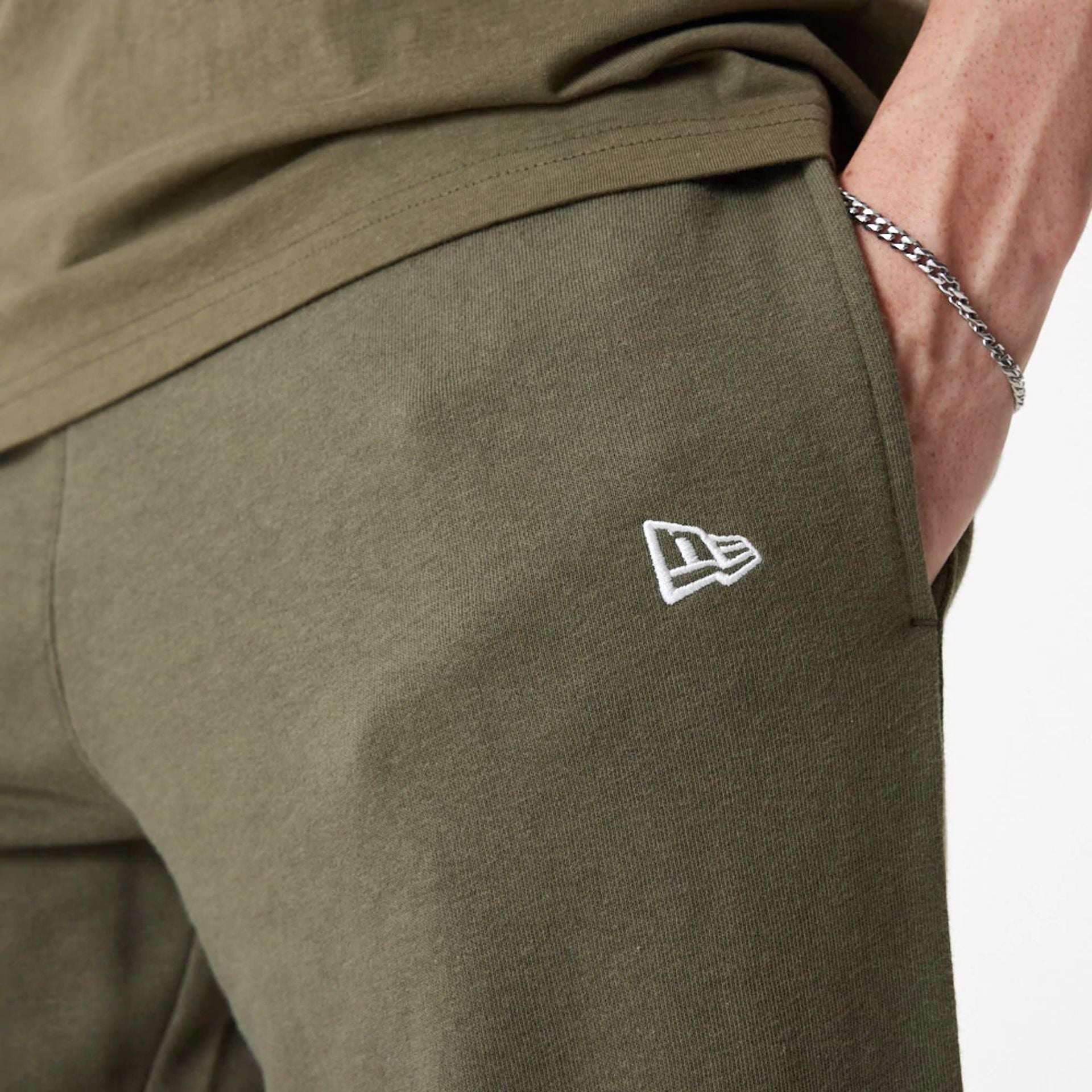 The Male model is wearing New Era Essential Green Joggers 3