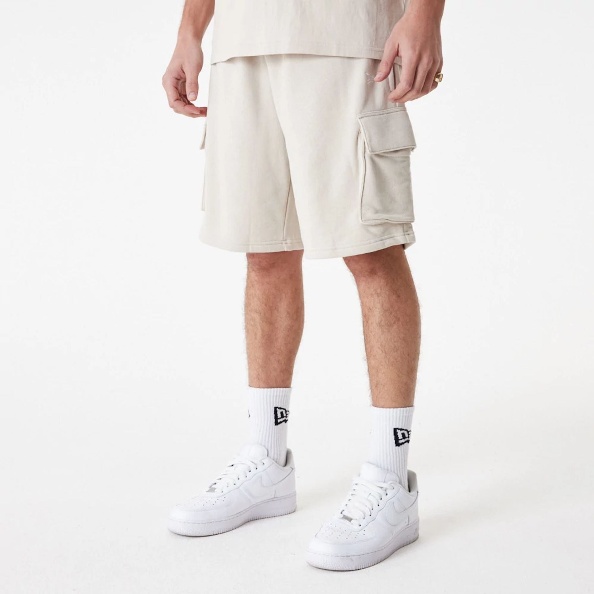 The Male model is wearing New Era Essential Stone Shorts 1