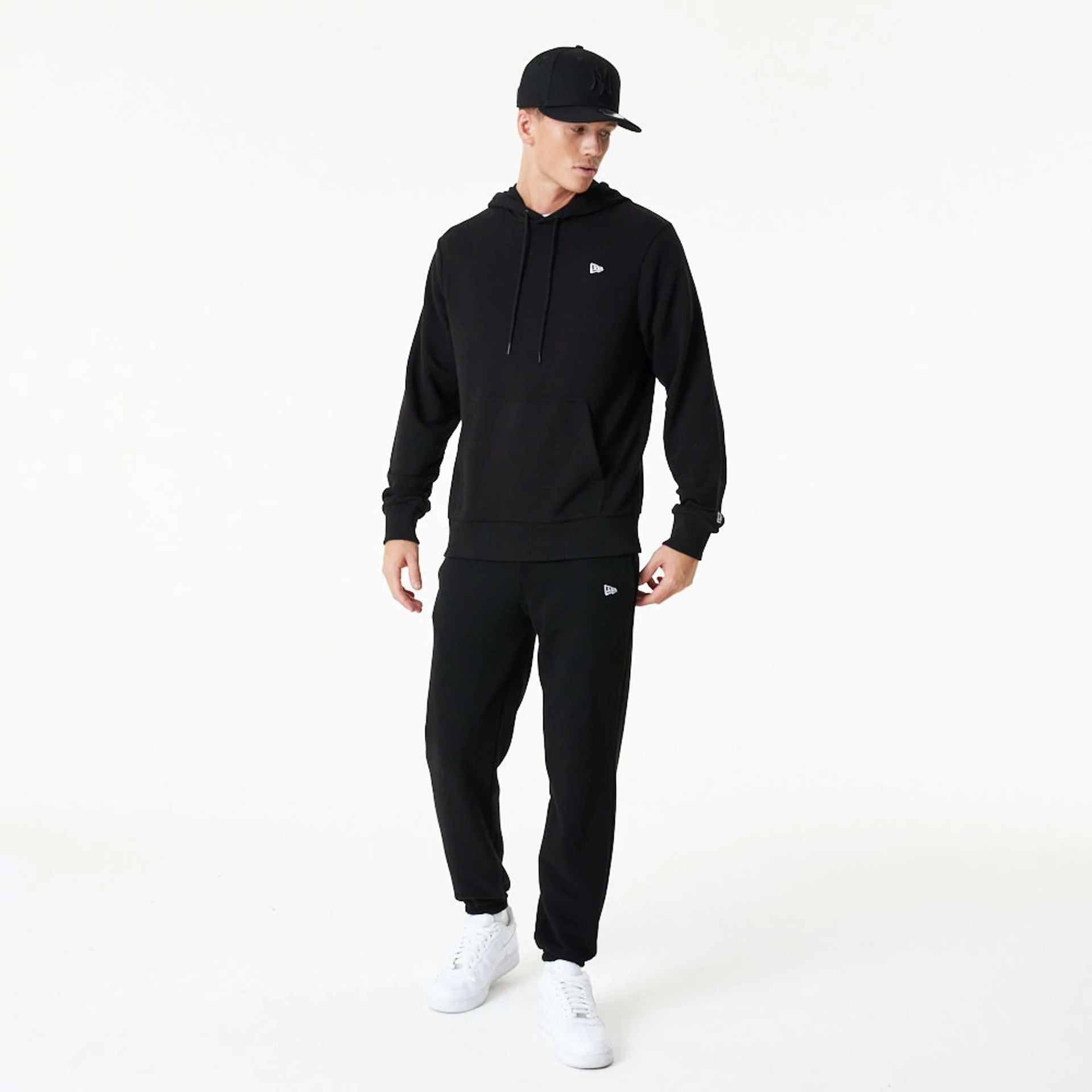 The Male model is wearing New Era Essential Black Pullover Hoodie 6