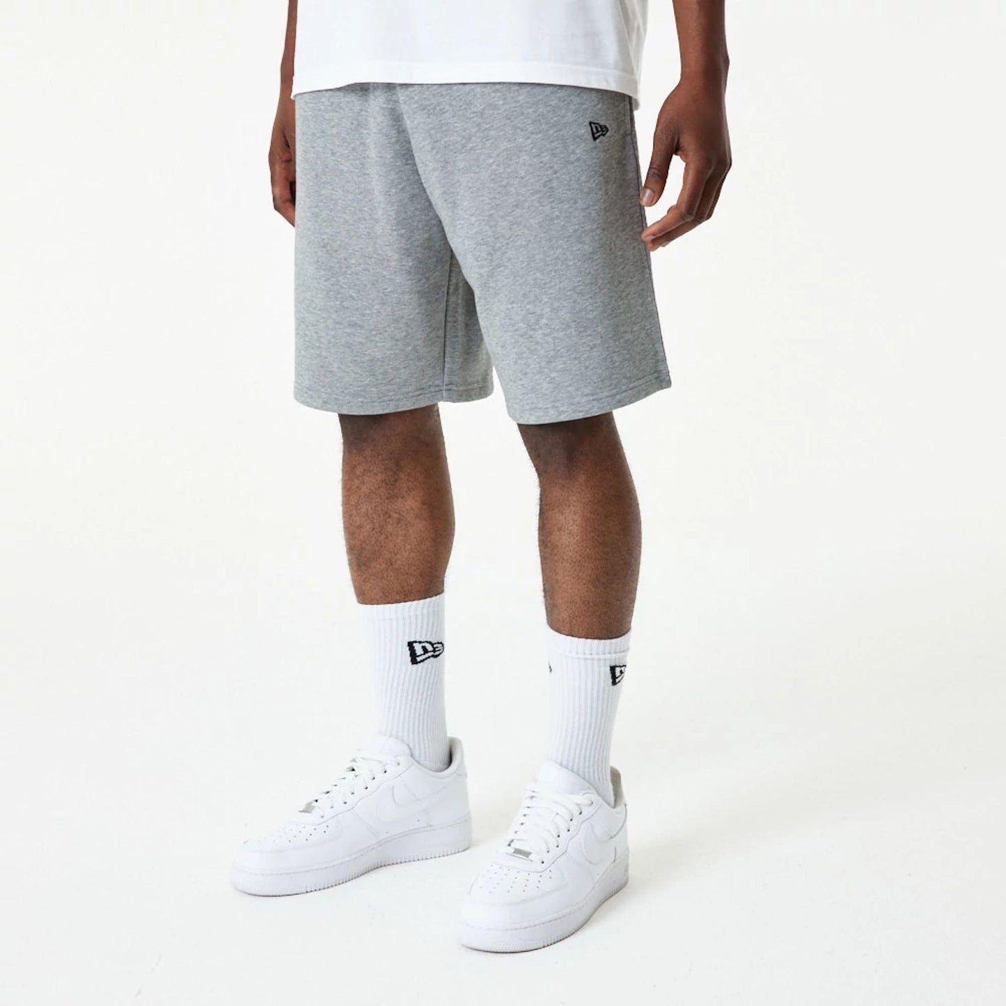 The Male model is wearing New Era Essential Grey Shorts 1