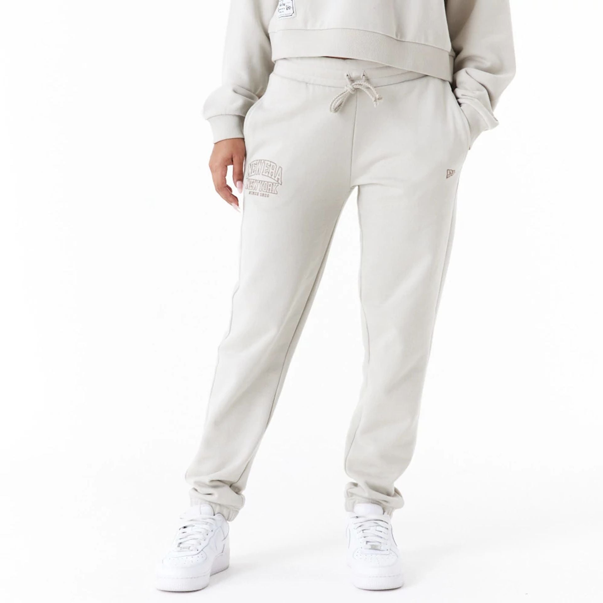 The Female model is wearing New Era Arch Wordmark Stone Womens Joggers 1