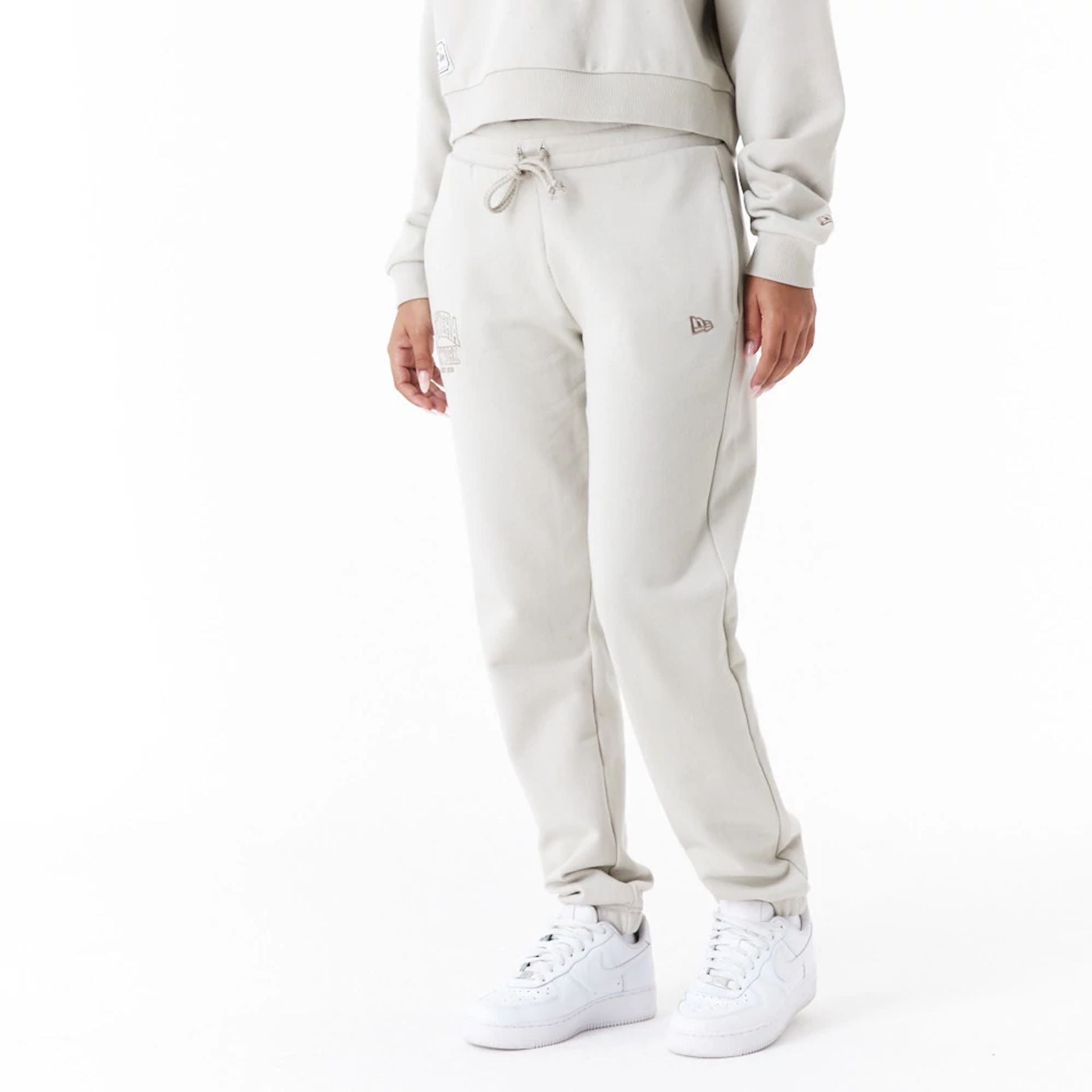 The Female model is wearing New Era Arch Wordmark Stone Womens Joggers 3