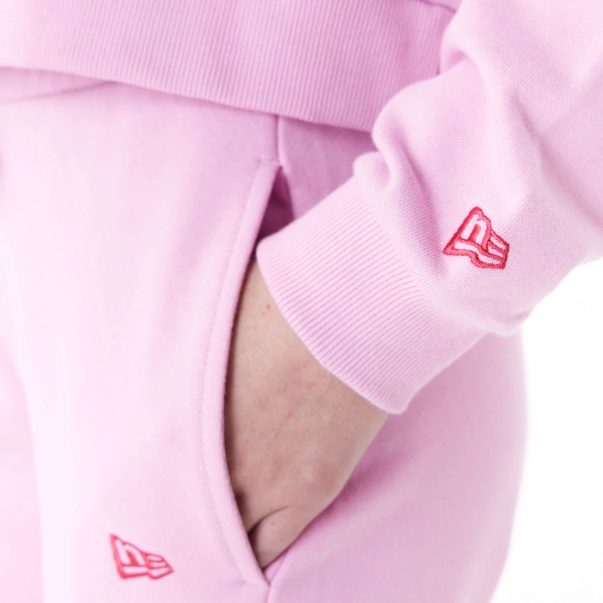 The Female model is wearing New Era Womens Arch Wordmark Pink Crop Pullover Hoodie 6