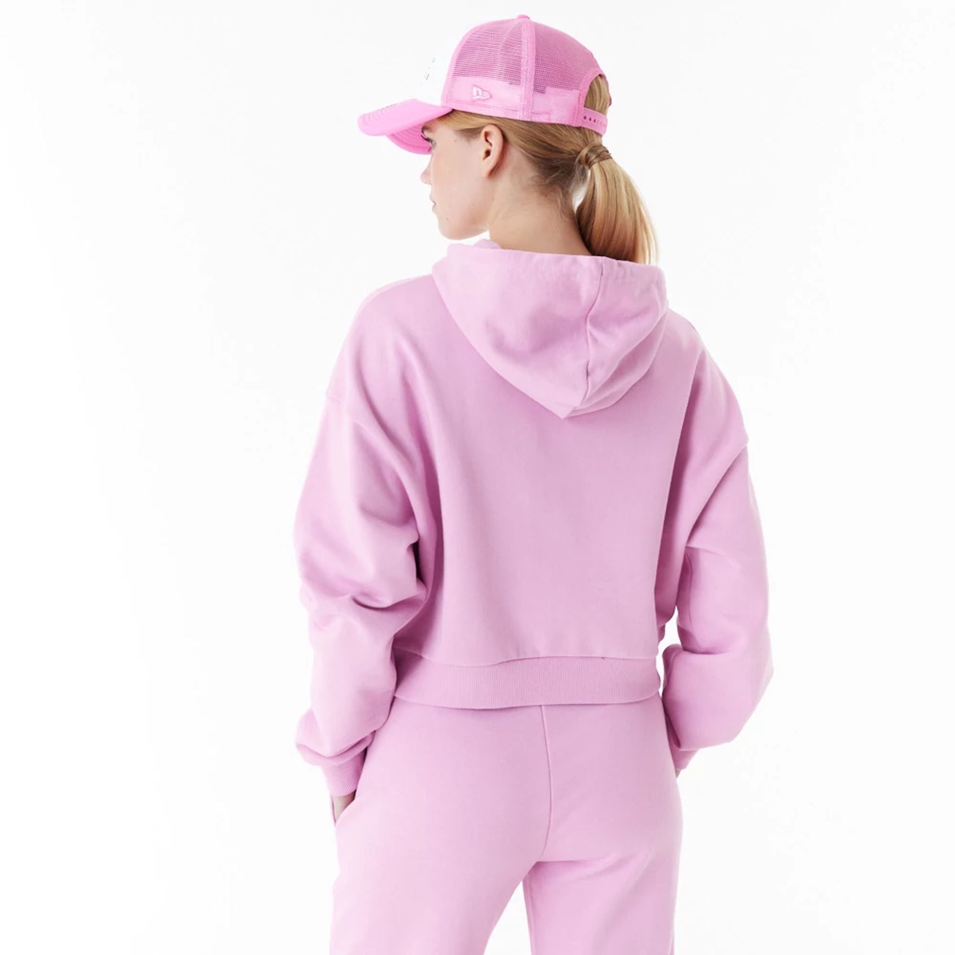 The Female model is wearing New Era Womens Arch Wordmark Pink Crop Pullover Hoodie 4