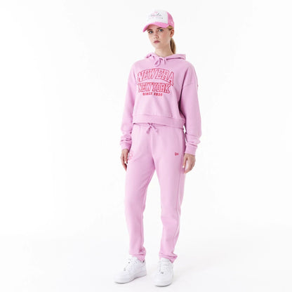 The Female model is wearing New Era Womens Arch Wordmark Pink Crop Pullover Hoodie 5