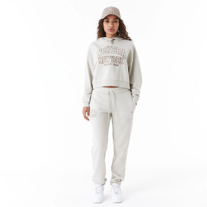 The Female model is wearing New Era Arch Wordmark Stone Womens Crop Pullover Hoodie 2