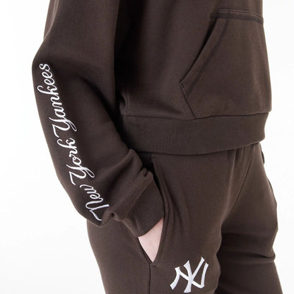 The Female model is wearing New York Yankees MLB Lifestyle Brown Womens Crop Pullover Hoodie 6