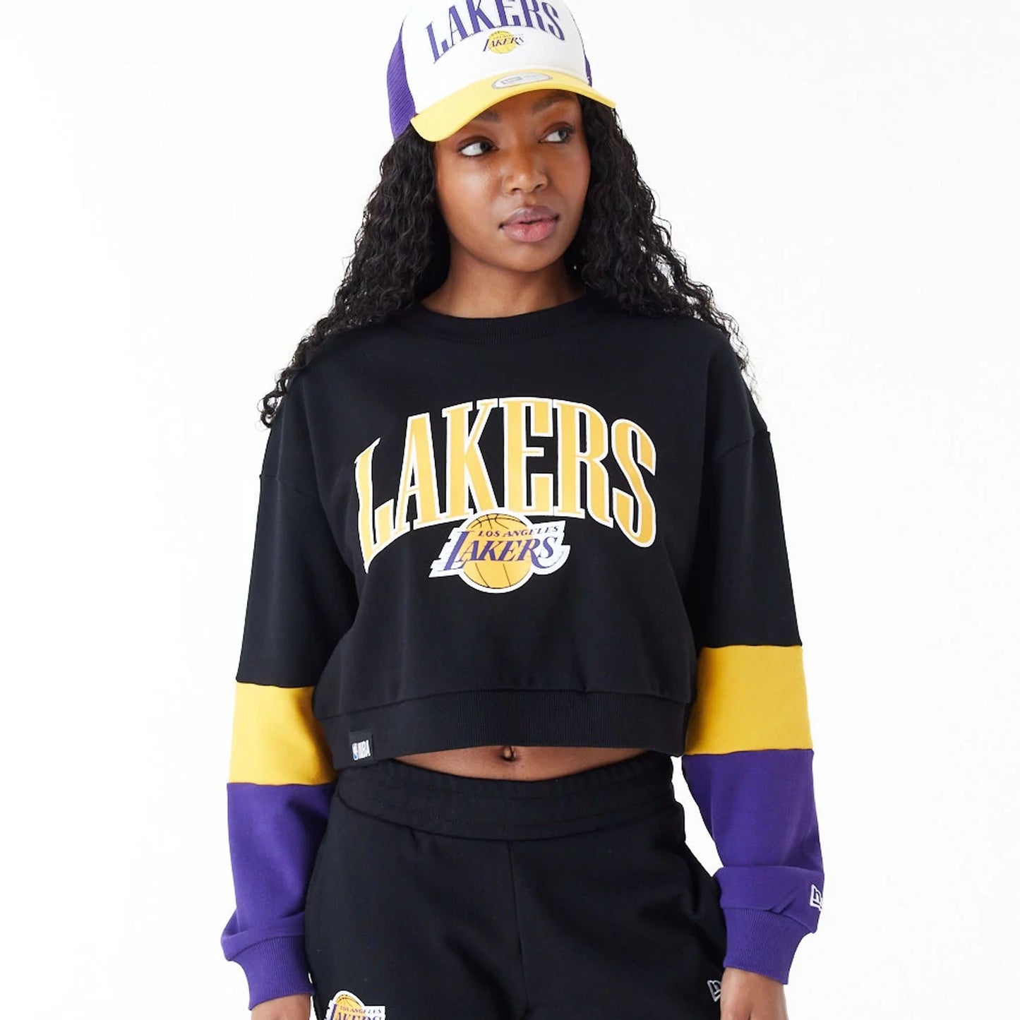 The Female model is wearing LA Lakers Womens NBA Colour Block Black Crop Crew Neck Sweatshirt 3