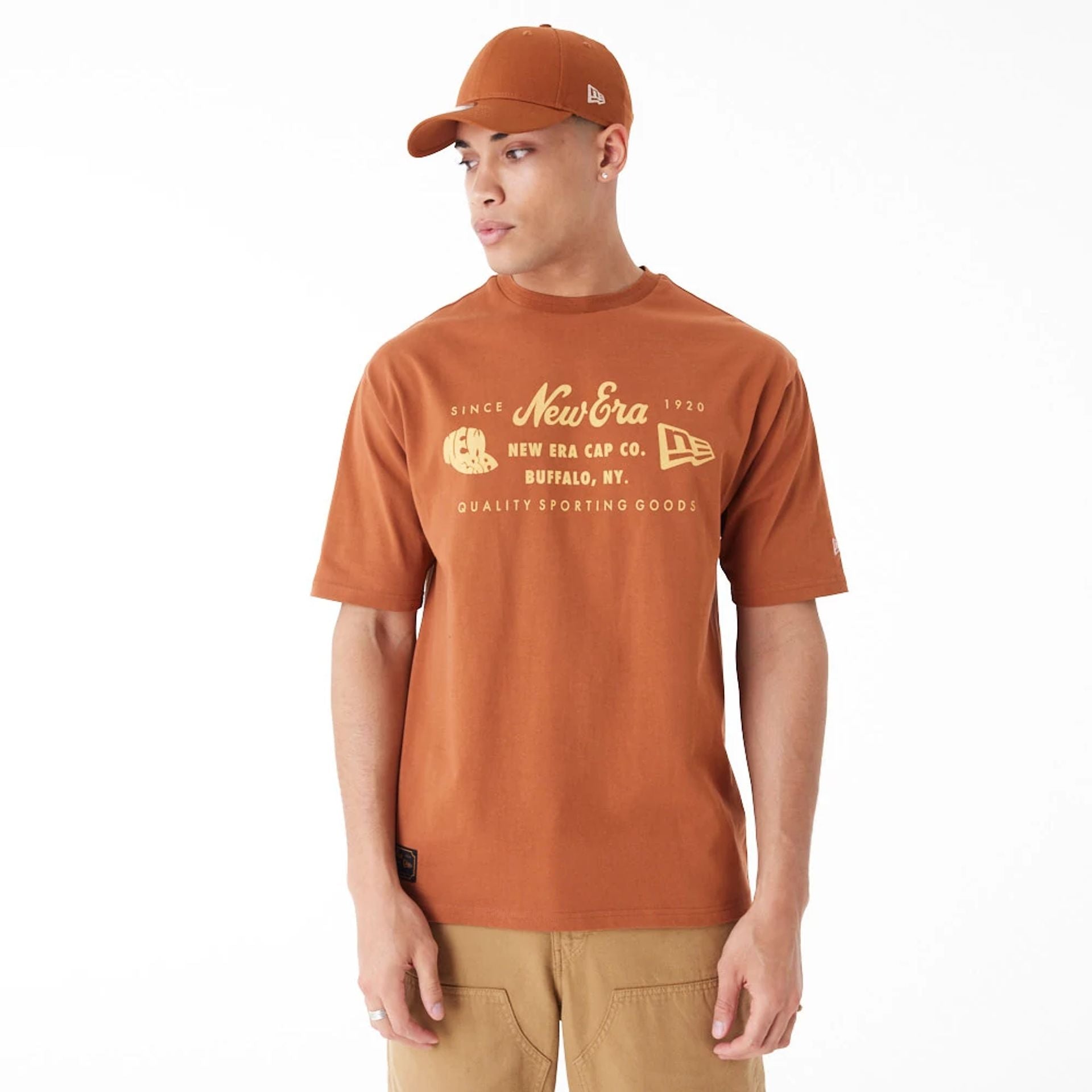 The Male model is wearing New Era Heritage Patch Brown Oversized T-Shirt 4