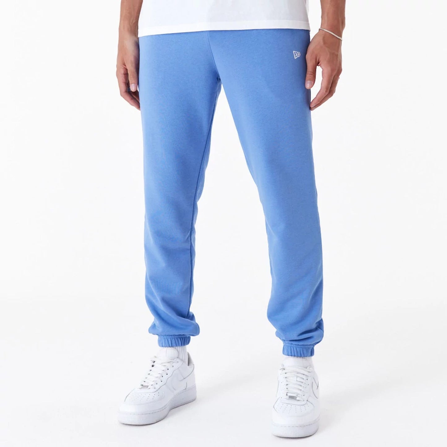 The Male model is wearing New Era Essential Blue Slim Joggers 1