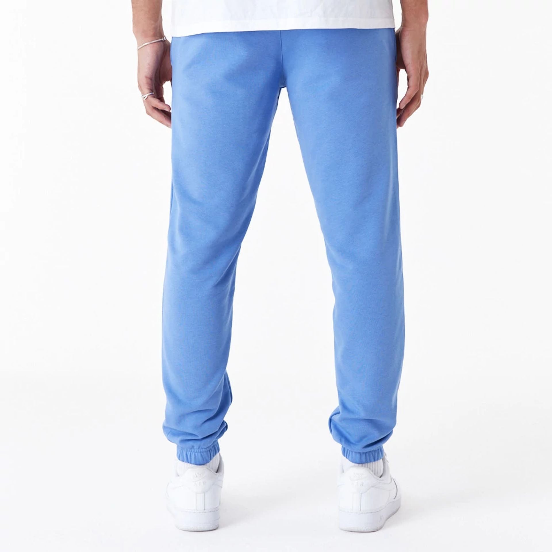 The Male model is wearing New Era Essential Blue Slim Joggers 4