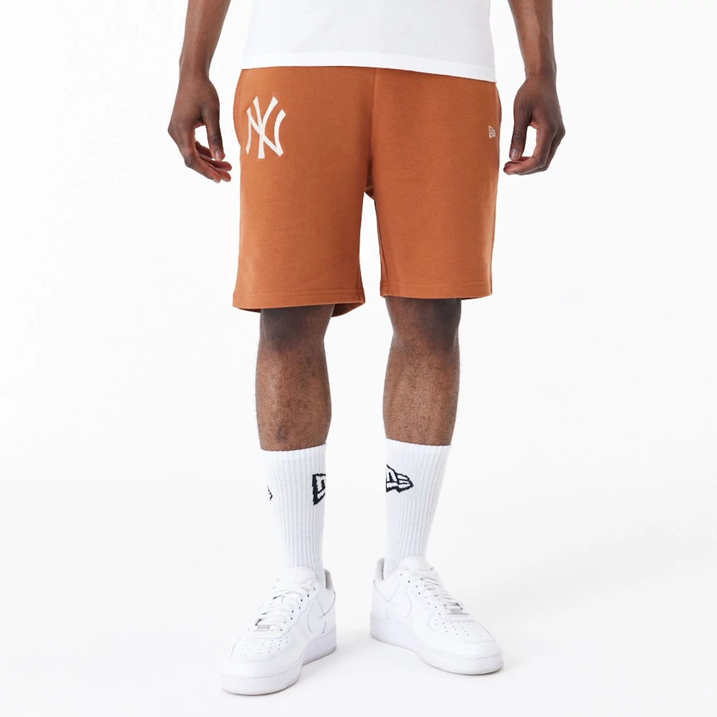 The Male model is wearing New York Yankees League Essential Brown Shorts 1