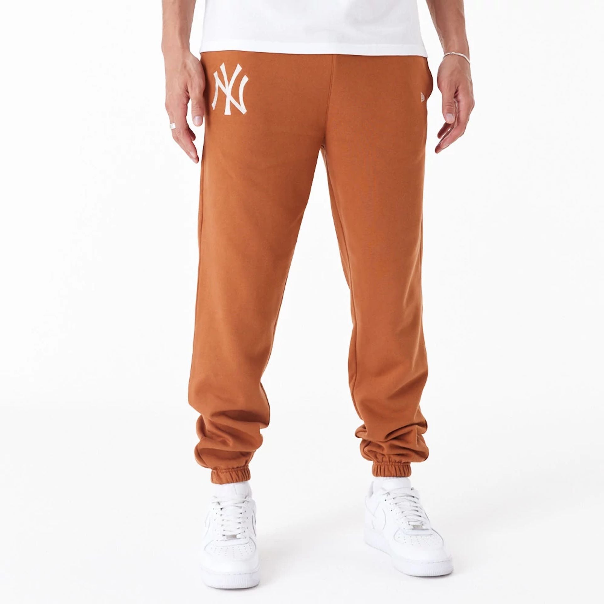 The Male model is wearing New York Yankees League Essential Brown Joggers 1