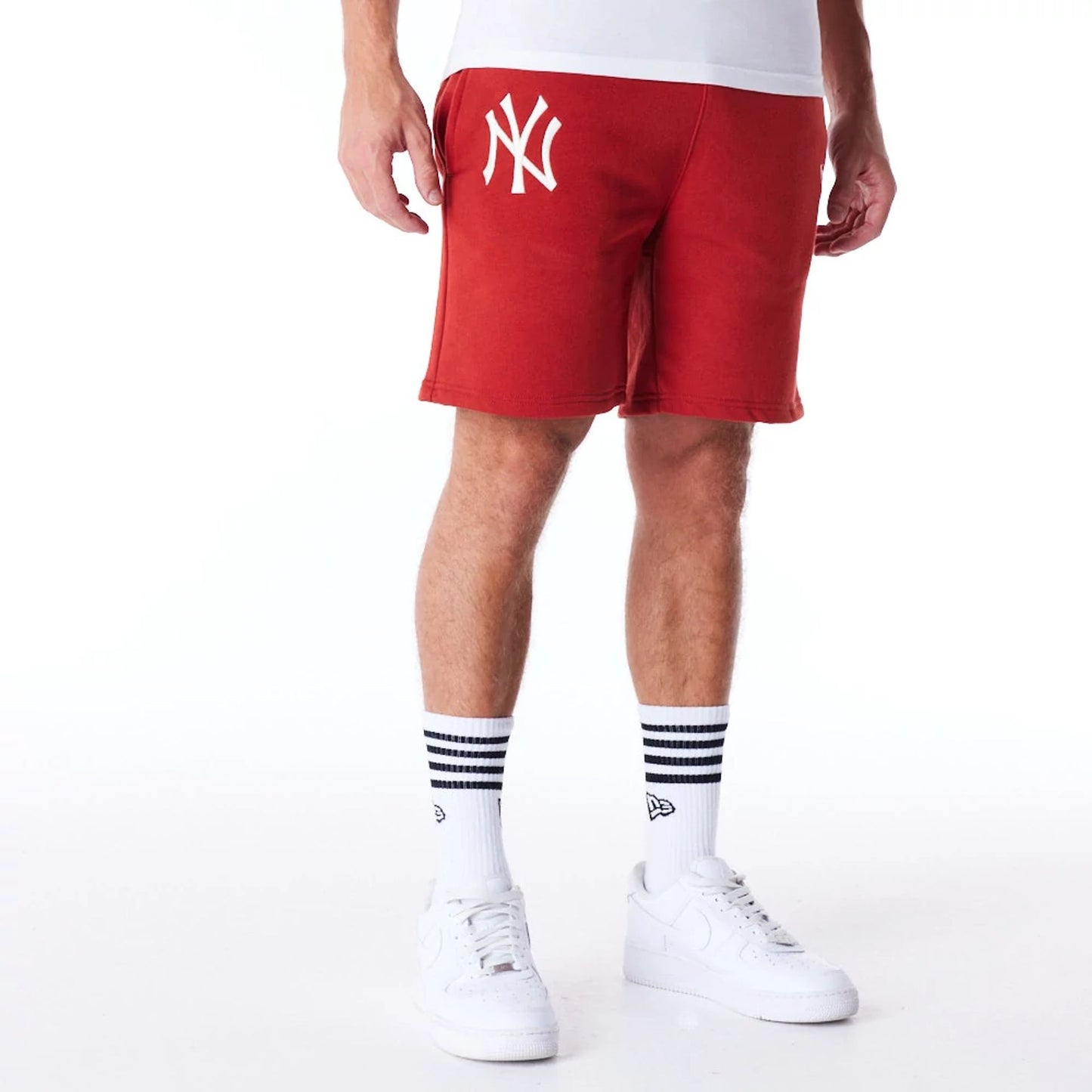 The Male model is wearing New York Yankees League Essential Red Shorts 1