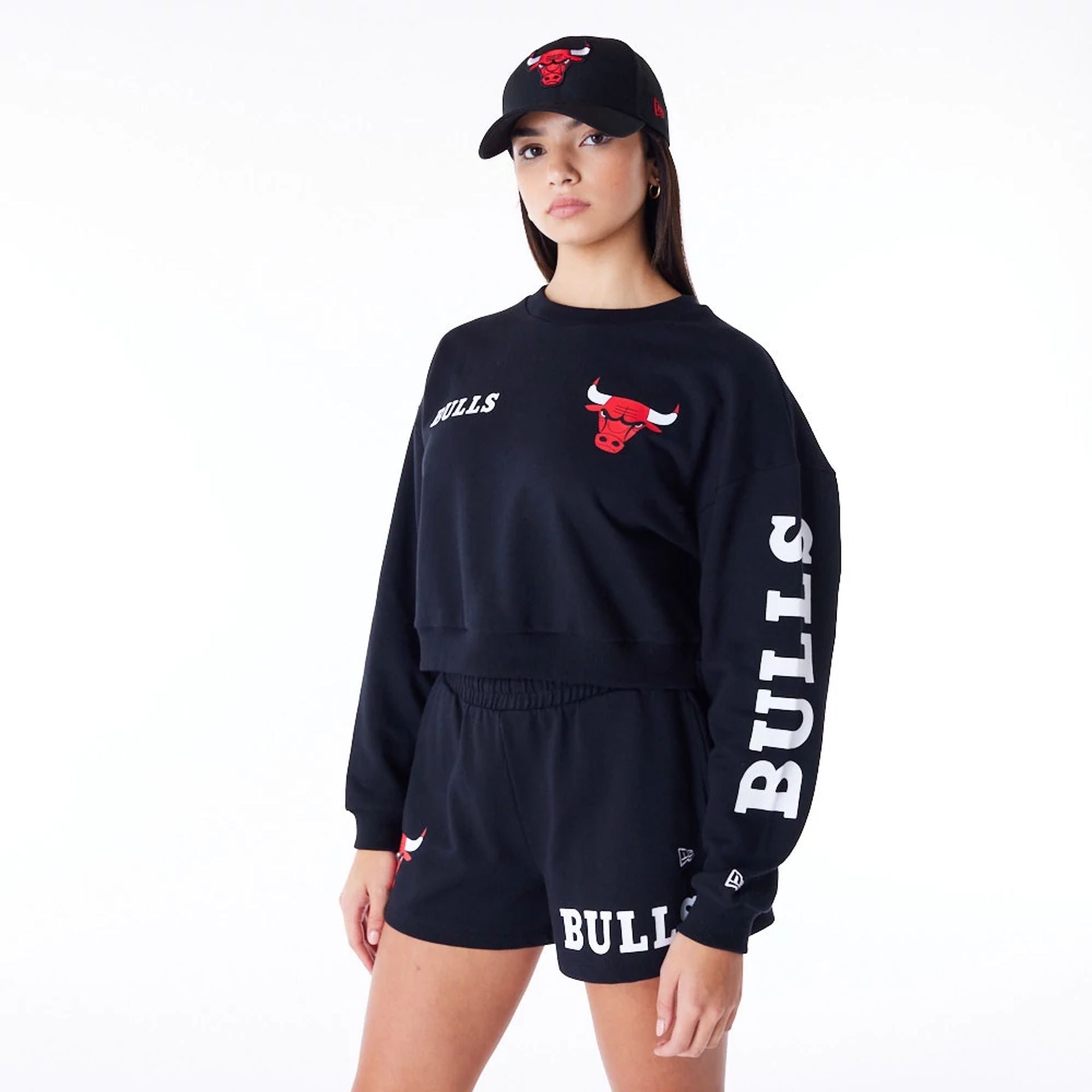 The Female model is wearing Chicago Bulls Womens NBA Wordmark Black Crop Crew Neck Sweatshirt 1