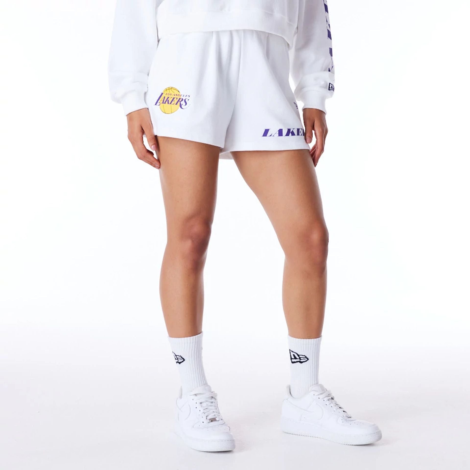 The Female model is wearing LA Lakers Womens NBA Wordmark White Shorts 1