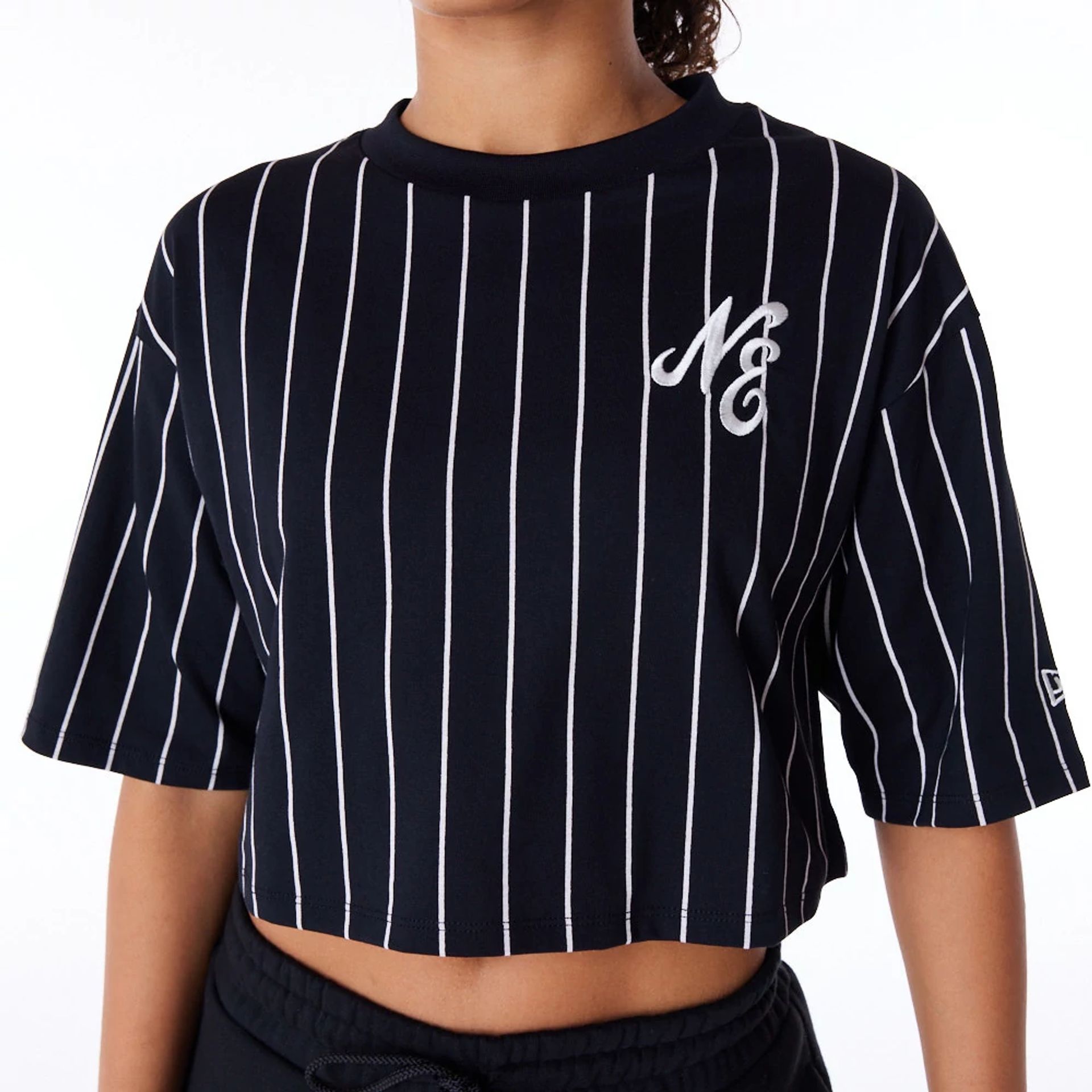 The Female model is wearing New Era Womens Pinstripe Black Crop T-Shirt 2