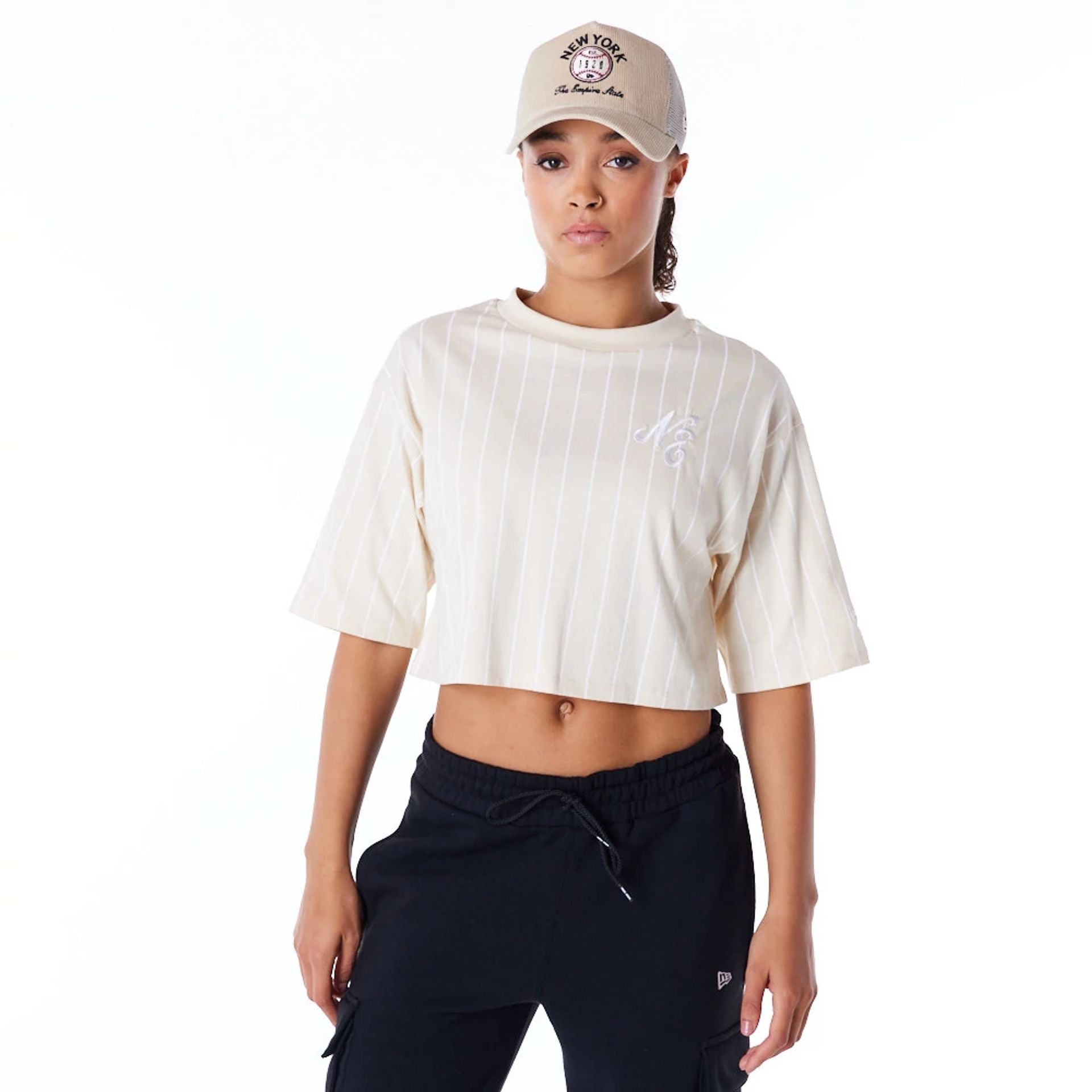 The Female model is wearing New Era Womens Pinstripe Light Beige Crop T-Shirt 1