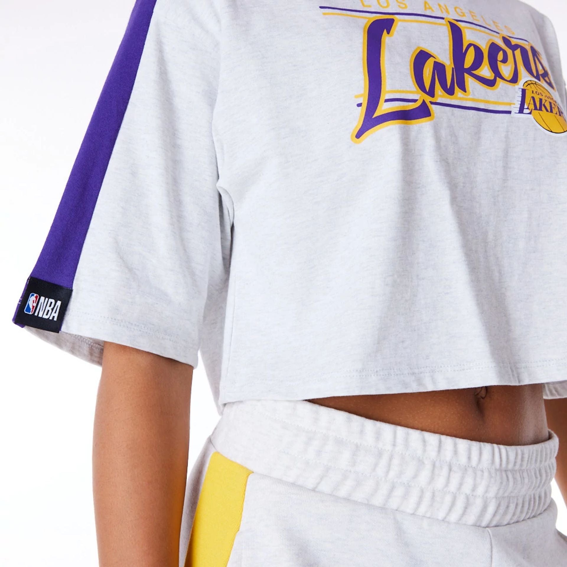 The Female model is wearing LA Lakers Womens NBA Colour Block Grey Crop T-Shirt 7