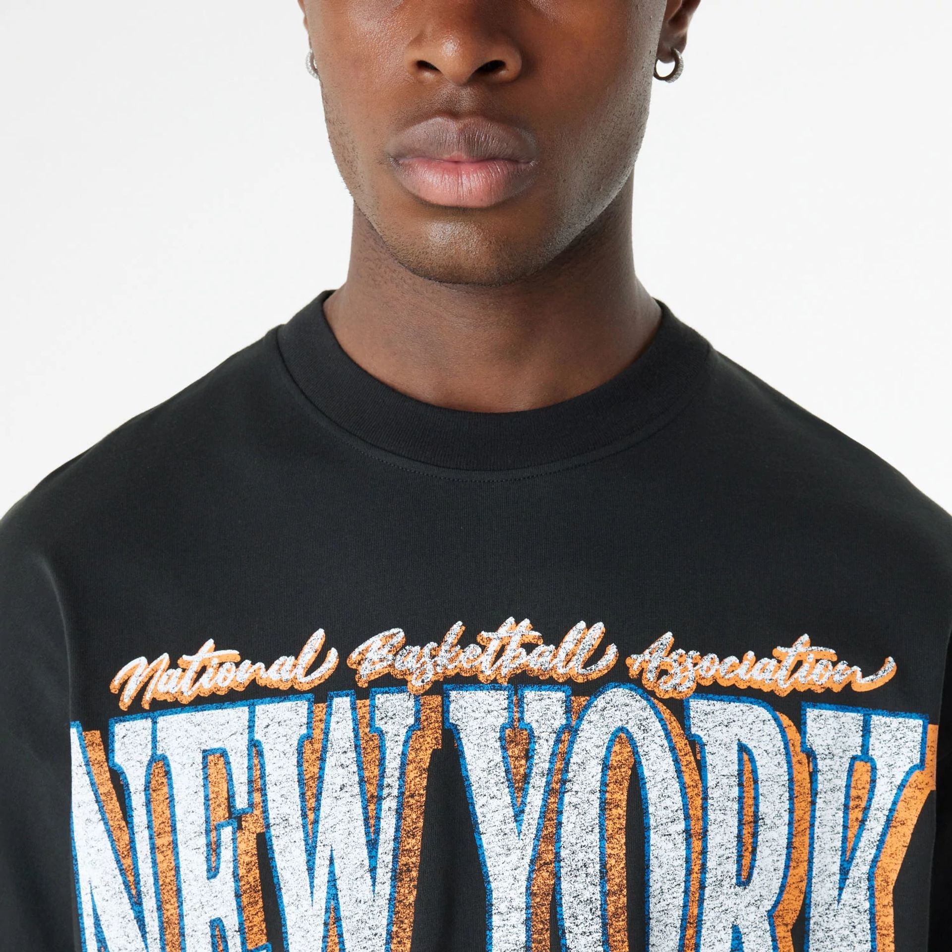 The Male model is wearing New York Knicks Oversized Essential Black Oversized T-Shirt 5