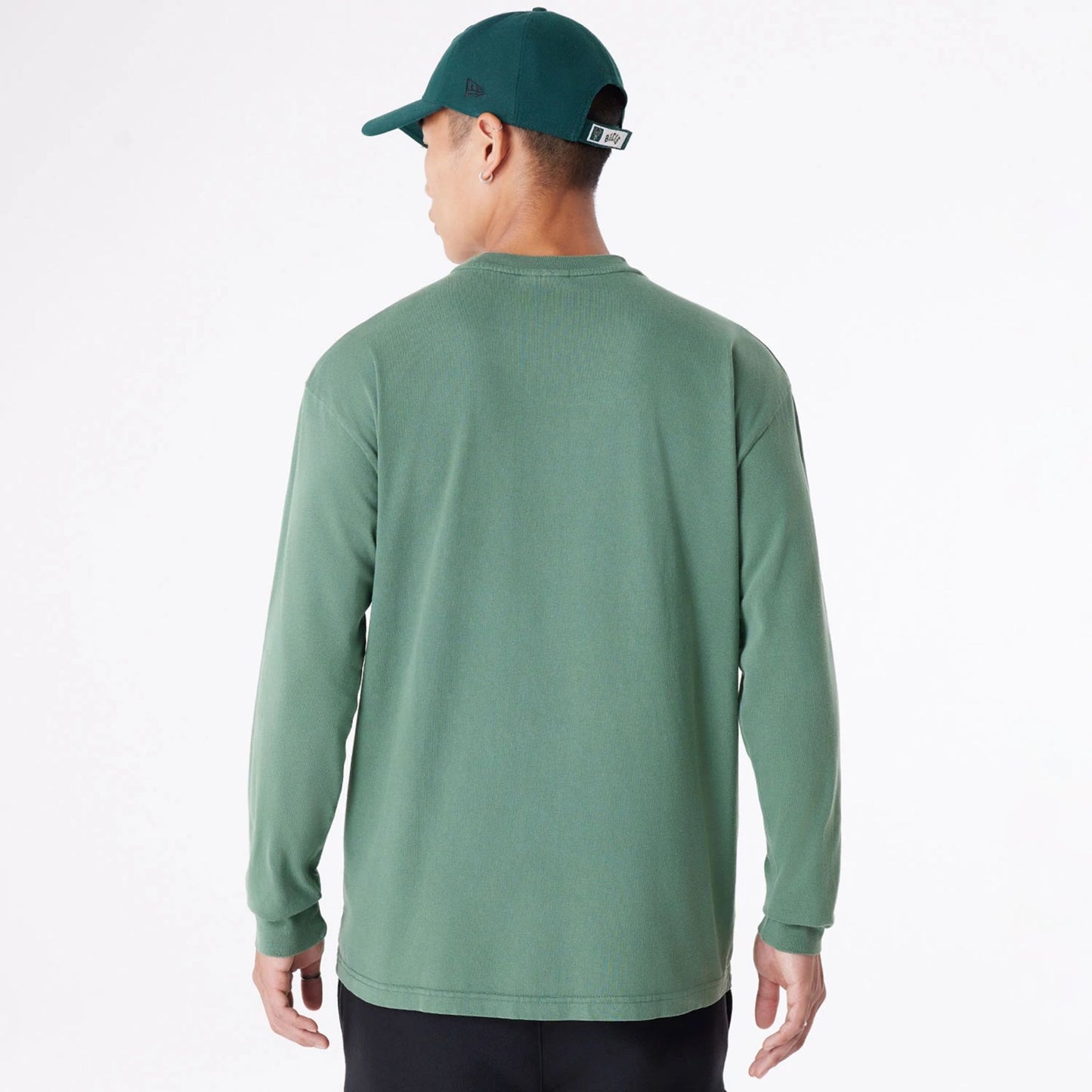 The Male model is wearing Milwaukee Bucks Oversized Essential Dark Green Oversized Long Sleeve T-Shirt 2