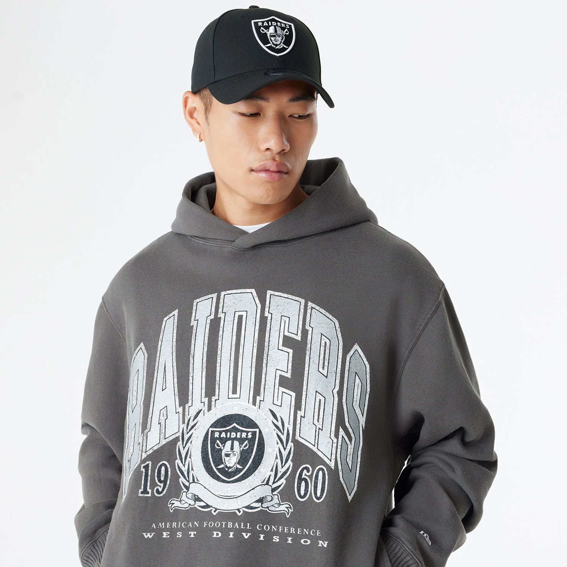 The Male model is wearing Las Vegas Raiders Oversized Essential Dark Grey Oversized Pullover Hoodie 6