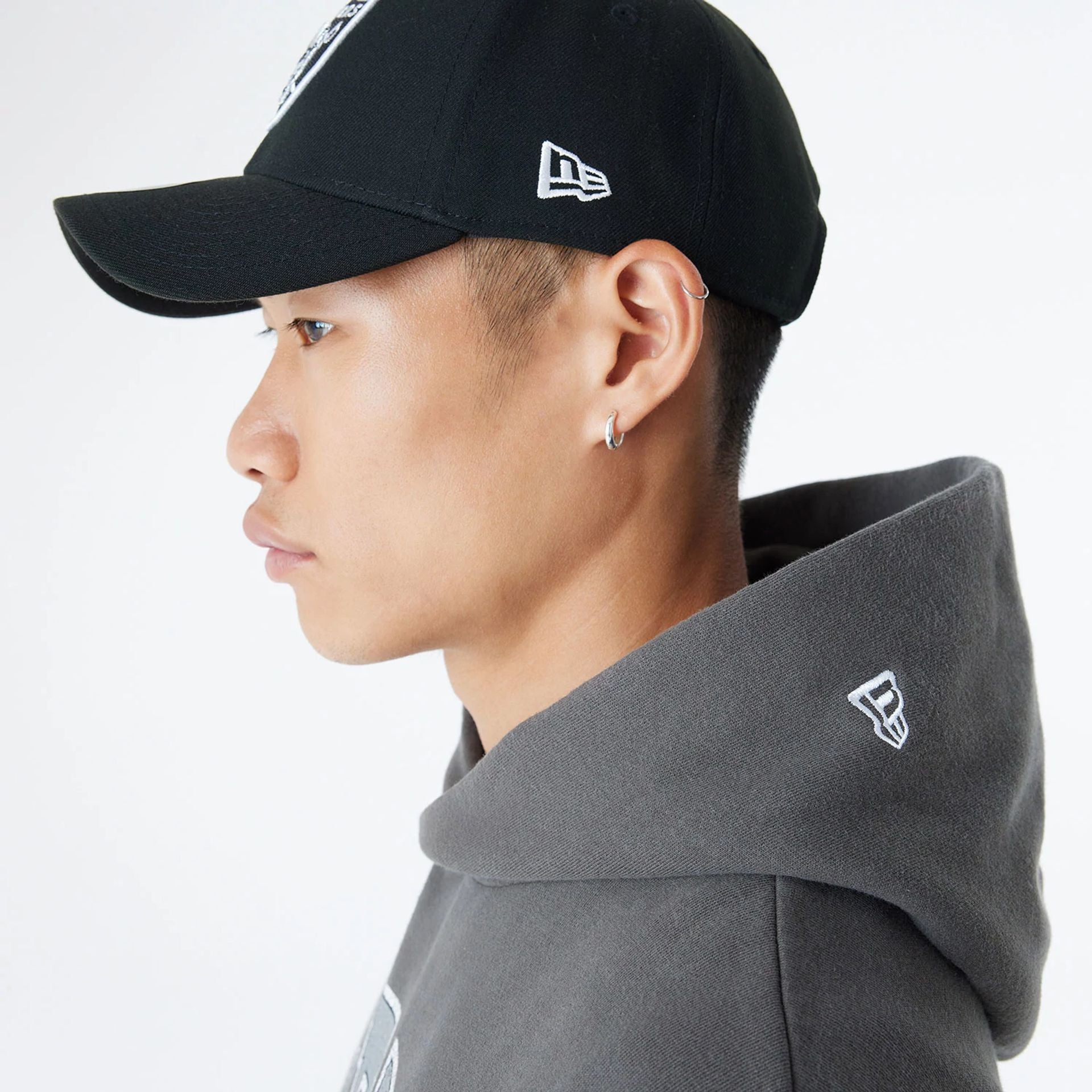 The Male model is wearing Las Vegas Raiders Oversized Essential Dark Grey Oversized Pullover Hoodie 5