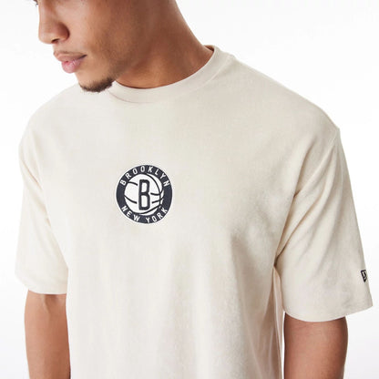 The Male model is wearing Brooklyn Nets NBA Lifestyle Velour Light Beige Oversized T-Shirt  6