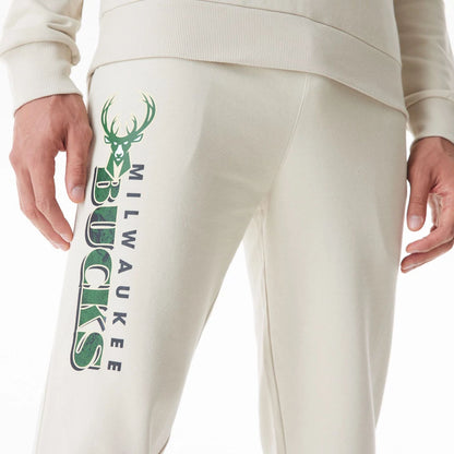 The Male model is wearing Milwaukee Bucks NBA Graphic Cream Joggers  3