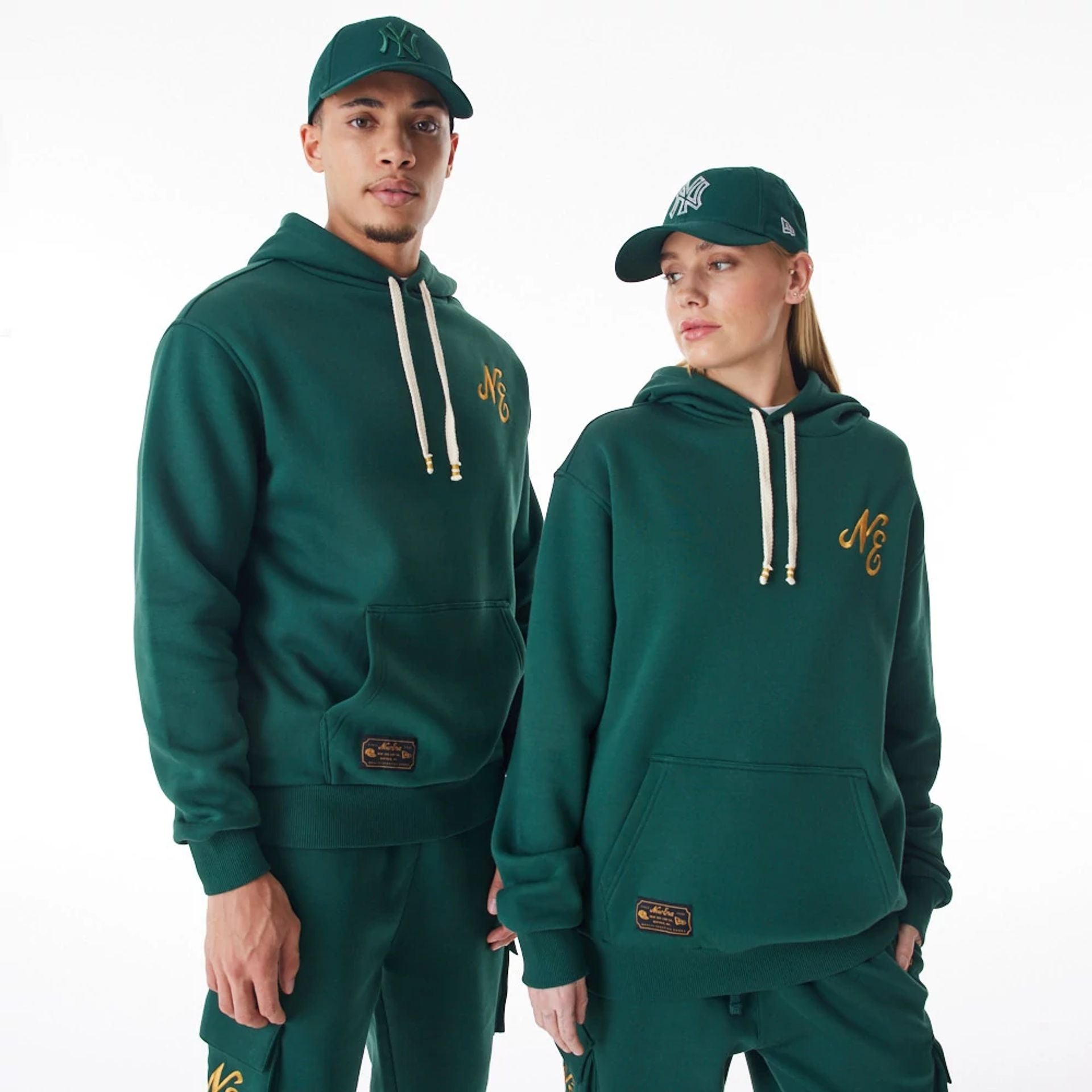 The Male model is wearing  New Era Script Logo Dark Green Oversized Pullover Hoodie  1