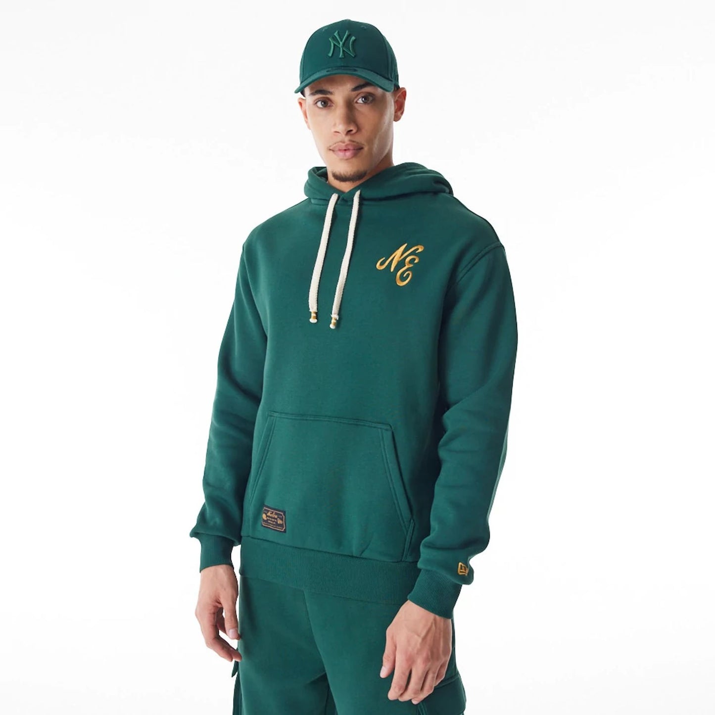 The Male model is wearing  New Era Script Logo Dark Green Oversized Pullover Hoodie  2