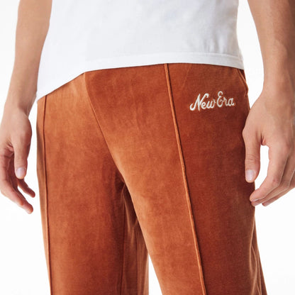 The Male model is wearing  New Era Velour Brown Track Joggers  8