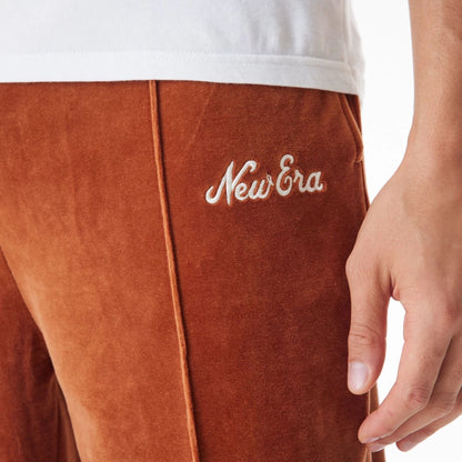 The Male model is wearing  New Era Velour Brown Track Joggers  6