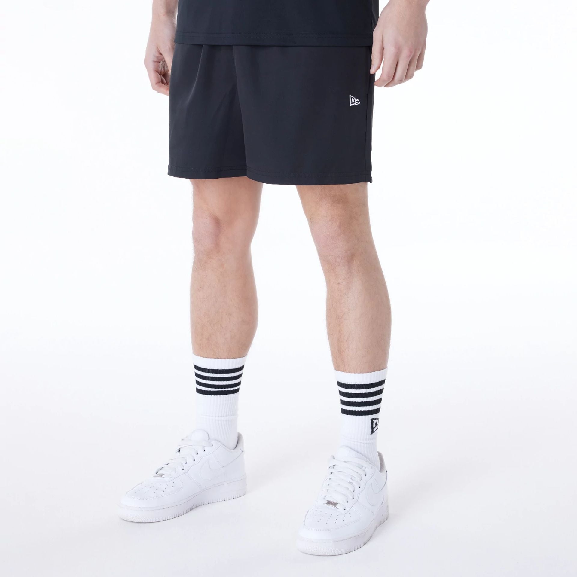 The Male model is wearing New Era Essential Black Shorts 1