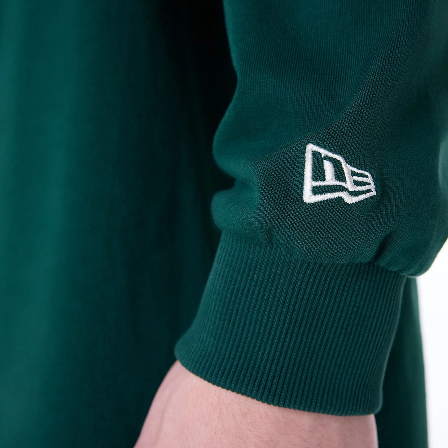 The Male model is wearing New Era Drop Shoulder Dark Green Rugby 7