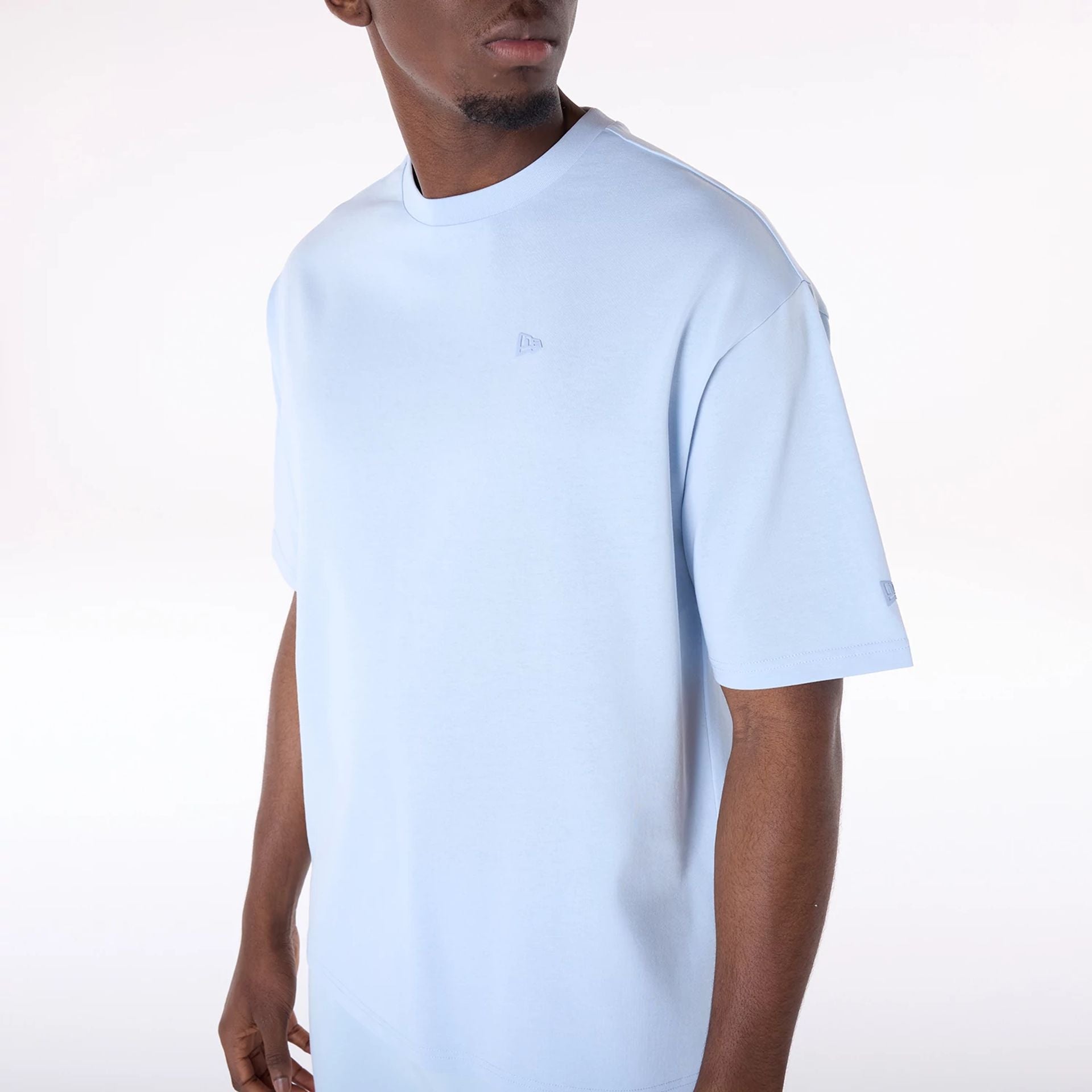 The Male model is wearing New Era Sticker Pastel Blue Oversized T-Shirt 8