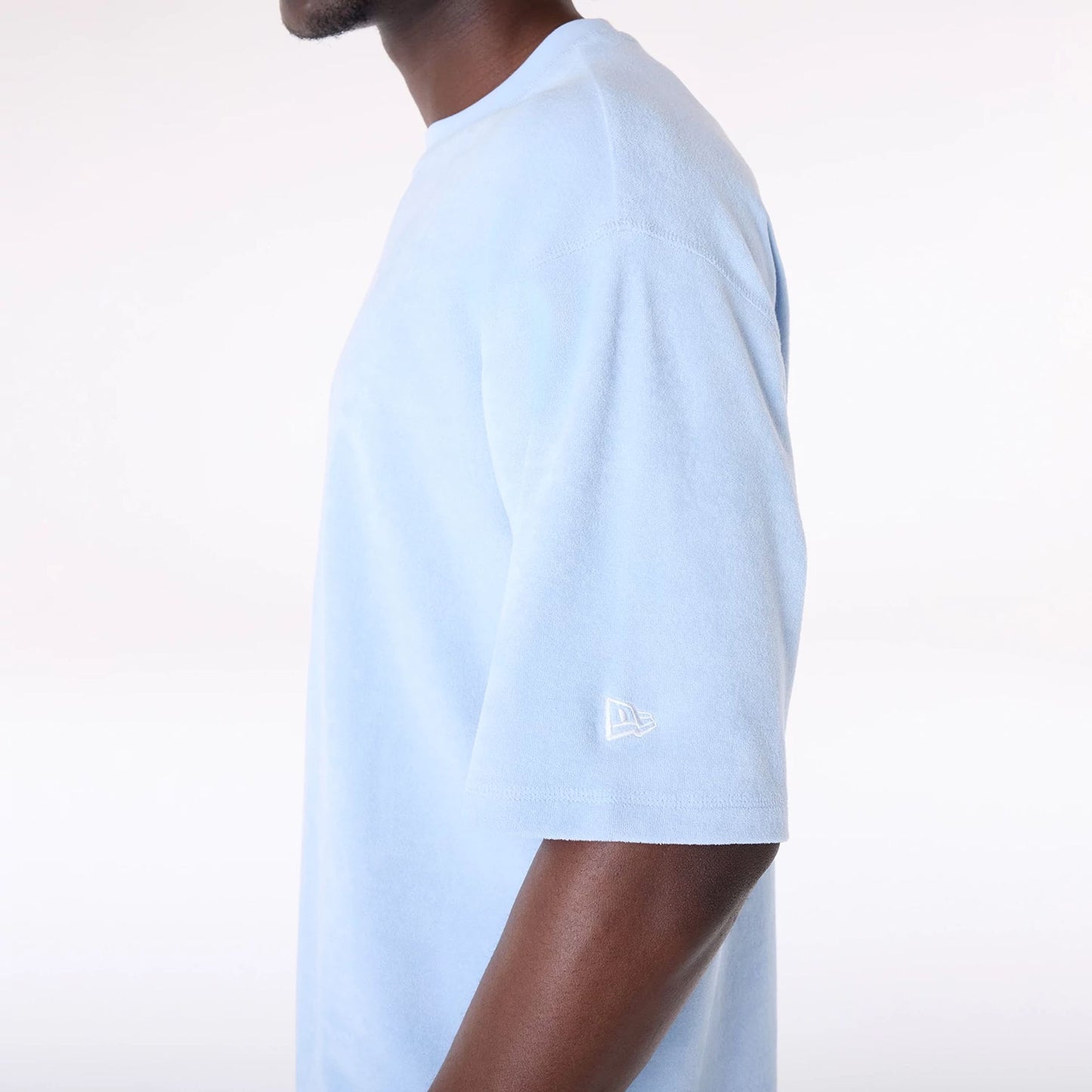 The Male model is wearing New Era Towelling Pastel Blue Oversized T-Shirt 6