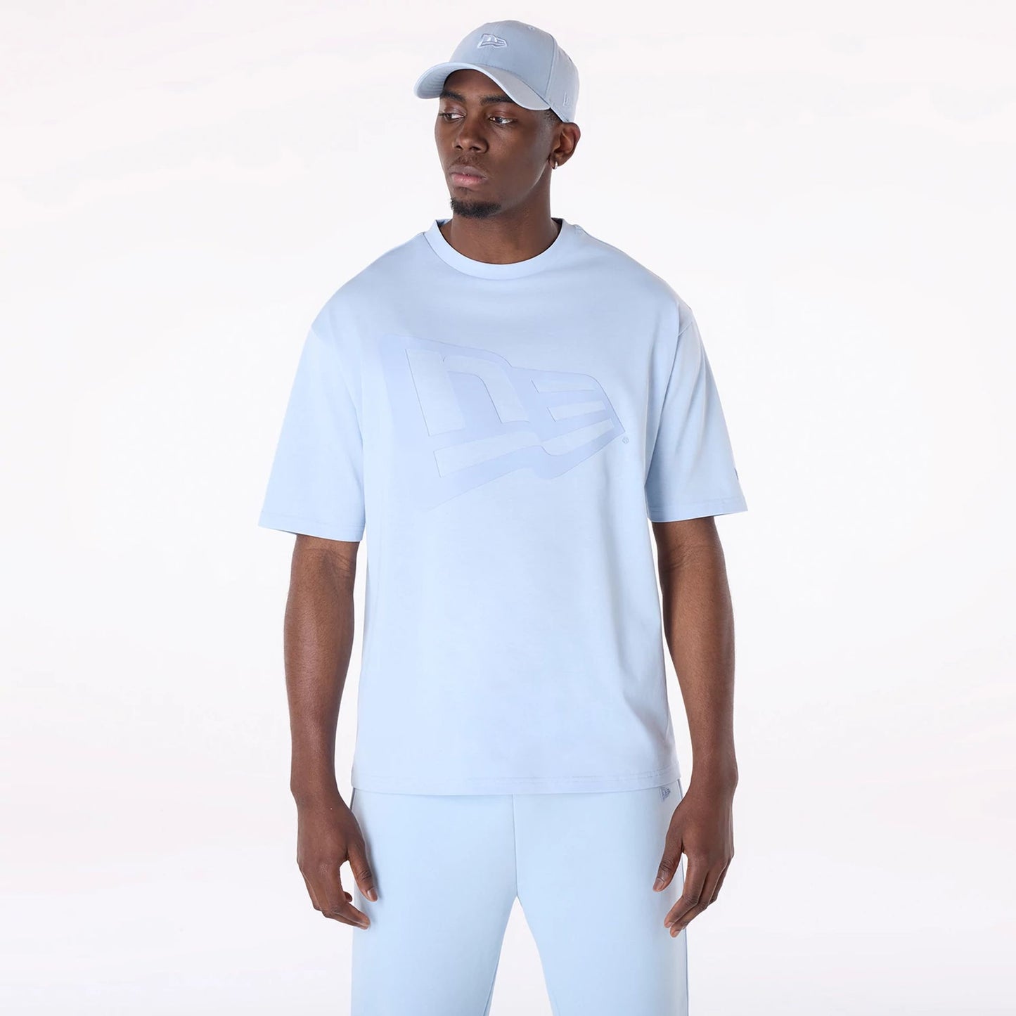 The Male model is wearing New Era Flag Pastel Blue Oversized T-Shirt 1