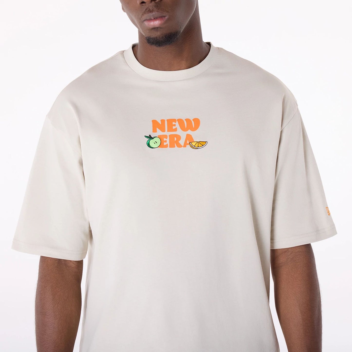 The Male model is wearing New Era Drink Graphic Cream Oversized T-Shirt 3