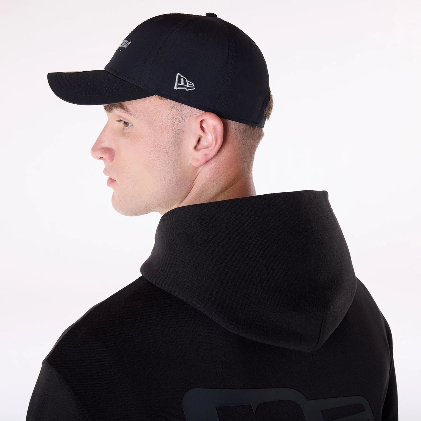 The Male model is wearing New Era Flag Black Oversized Pullover Hoodie 5