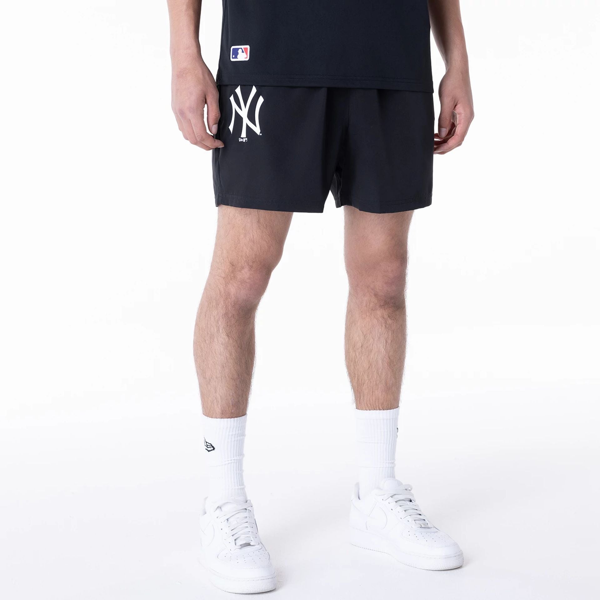 The Male model is wearing New York Yankees League Essential Black Shorts 1