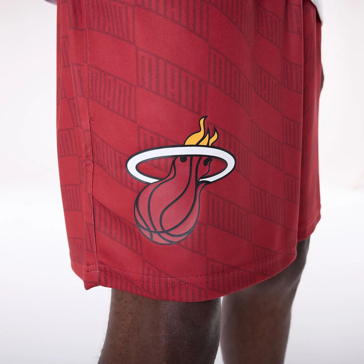 The Male model is wearing Miami Heat NBA All Over Print Graphic Dark Red Shorts 3