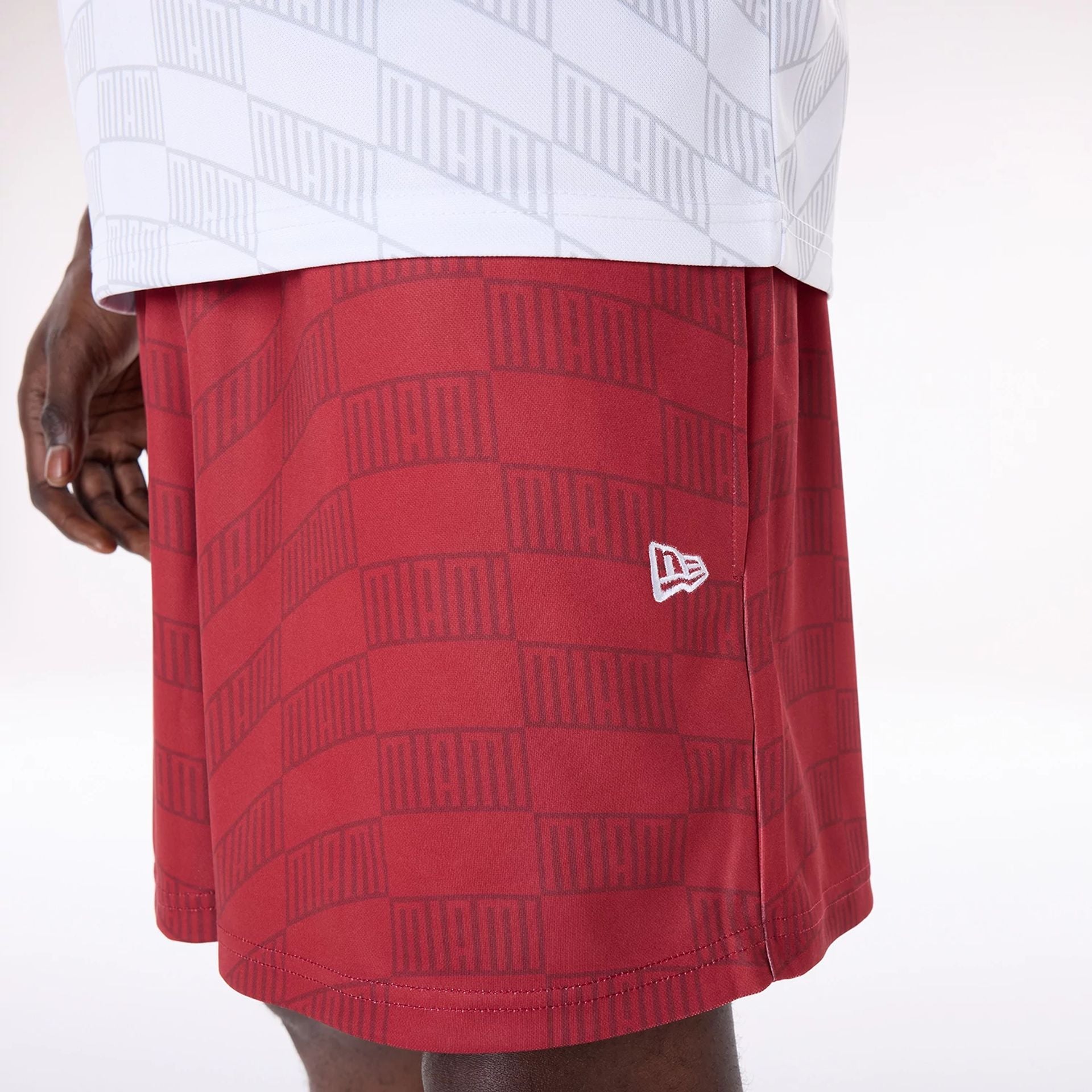 The Male model is wearing Miami Heat NBA All Over Print Graphic Dark Red Shorts 7